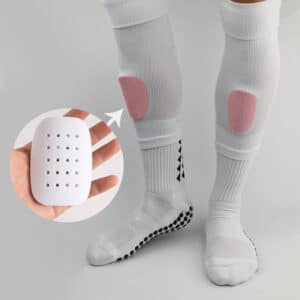 Une paire de mini protège-tibia professionnelle en éponge respirante avec trous